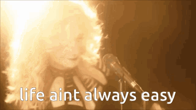 a woman singing into a microphone with the words life ain t always easy written below her