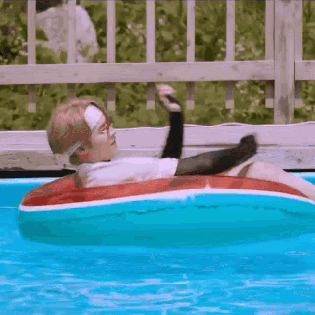a man is floating on an inflatable ring in a pool .