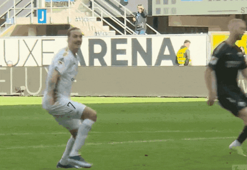 soccer players on a field with a sign in the background that says arena