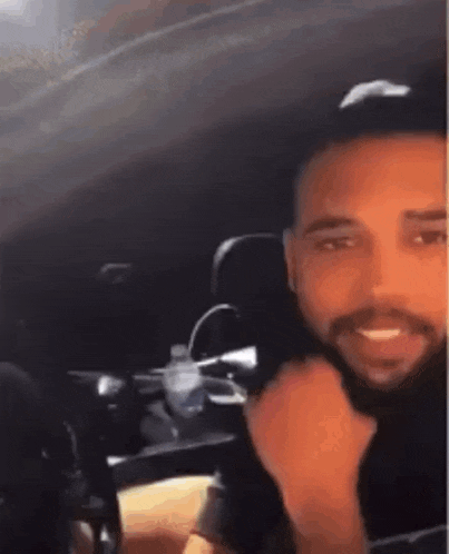 a man with a beard is sitting in the back seat of a car smiling .
