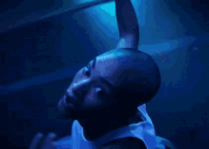 a woman in a white tank top is dancing in a dark room with blue lights .