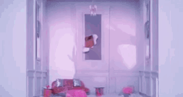 ariana grande is looking out of a hole in a pink wall .