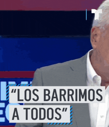 a man in a suit stands in front of a sign that says los barrimos a todos