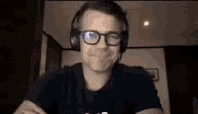 a man wearing glasses and headphones is sitting at a table .
