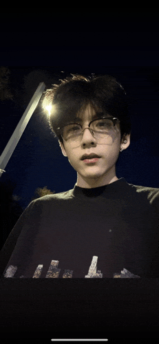 a young man wearing glasses and a black sweater with the letter l on it