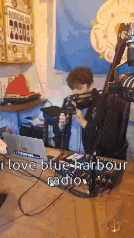 a man sitting in front of a microphone with the words i love blue harbour radio written on the bottom