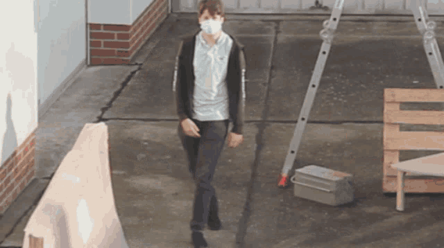 a man wearing a mask is walking on a sidewalk