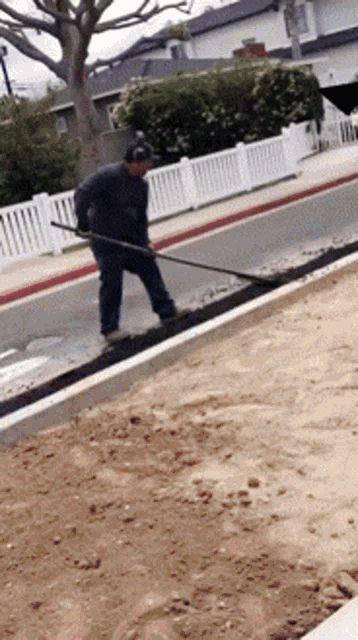 a man is using a broom to clean up the sidewalk