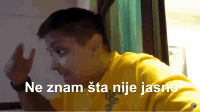 a woman in a yellow shirt says ne znam sta nije jasno