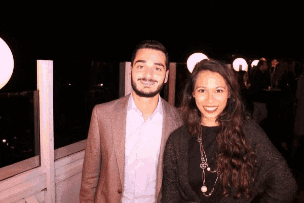 a man and a woman are posing for a picture in a dark room