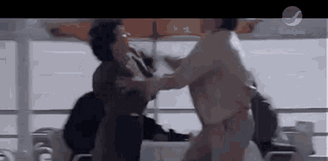 a couple of people are standing next to each other and fighting on a boat .