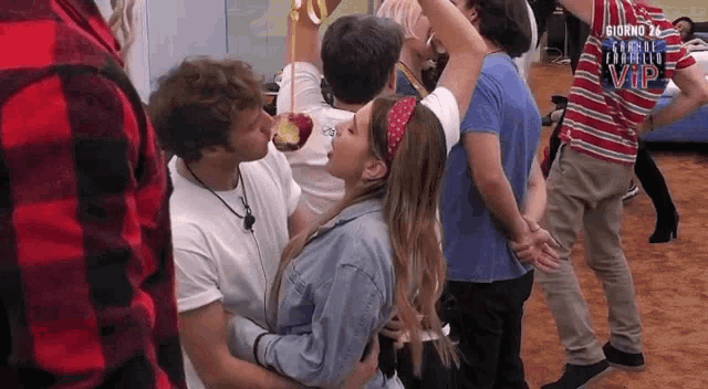 a man is kissing a woman on the cheek in a crowd of people