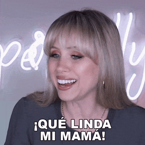 a woman with blonde hair is smiling and says " que linda mi mama "