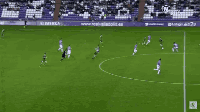 a soccer game is being played on a soccer field with empty seats .