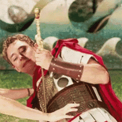 a man in a roman costume is holding a spear