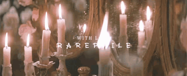 a bunch of candles are lit up in front of a mirror with the words " with l raremile " on the bottom
