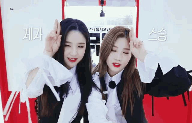 two girls giving the peace sign in front of a sign that says ' sss ' on it