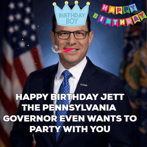 a man in a suit and tie with a birthday boy hat on