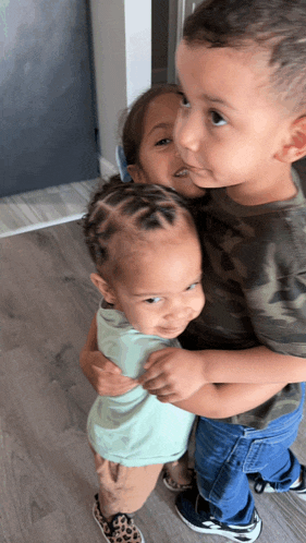 a boy and a girl are hugging each other on the floor