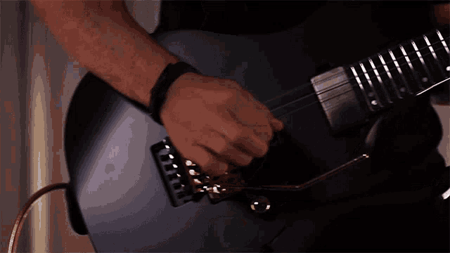 a man is playing a guitar with a black body