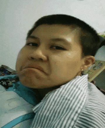 a young boy with short hair is making a funny face