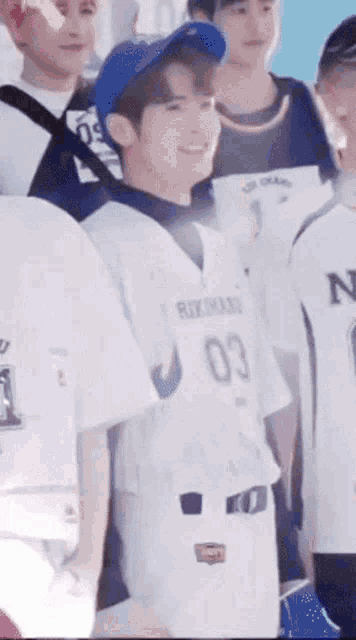 a group of young men are standing next to each other wearing baseball jerseys .