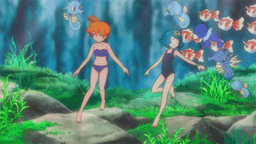 a couple of girls in bikinis are standing on a rock in the water