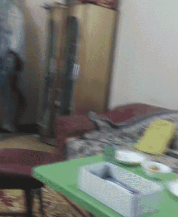 a blurry picture of a living room with a green table