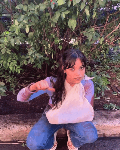 a young girl with a cast on her arm giving a thumbs down