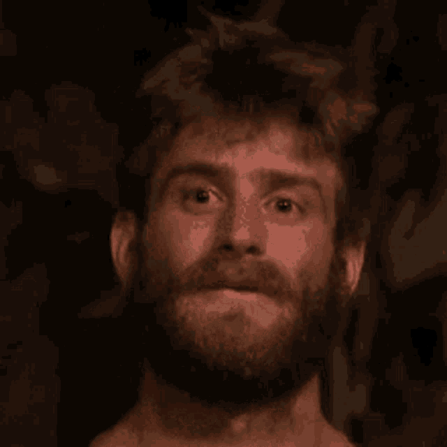 a close up of a man with a beard making a funny face .