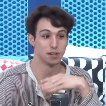 a young man in a striped shirt is sitting on a couch