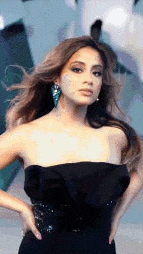 a woman in a black strapless dress and earrings