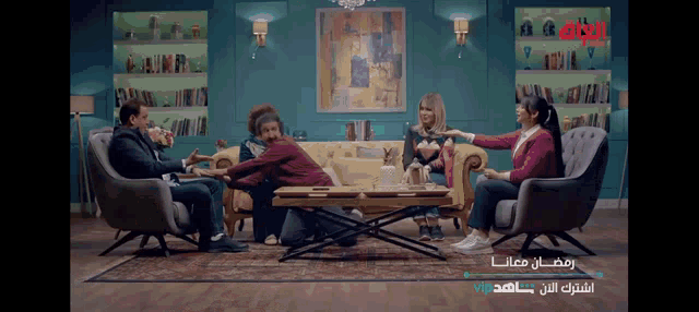 a group of people sitting around a table with arabic writing on the bottom right