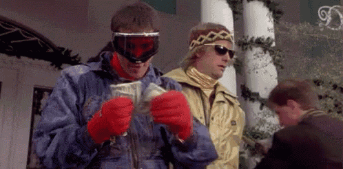 two men are standing next to each other holding a bunch of money in their hands .
