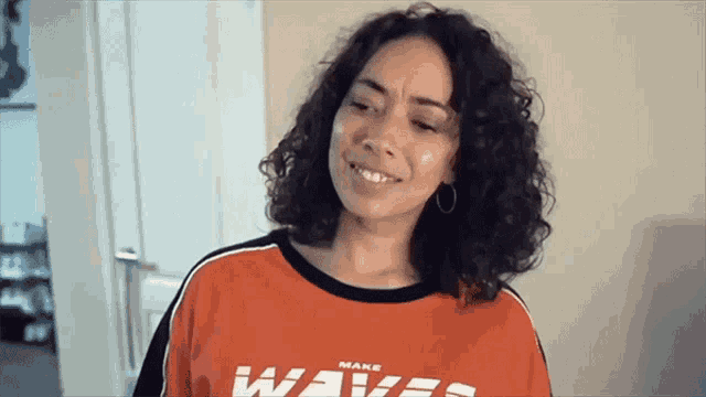 a woman is wearing a red shirt that says make waves
