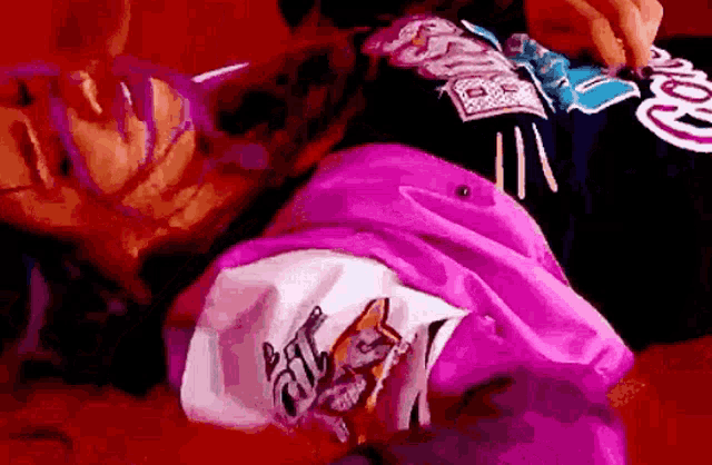 a woman is laying on a couch with a pink shirt on .
