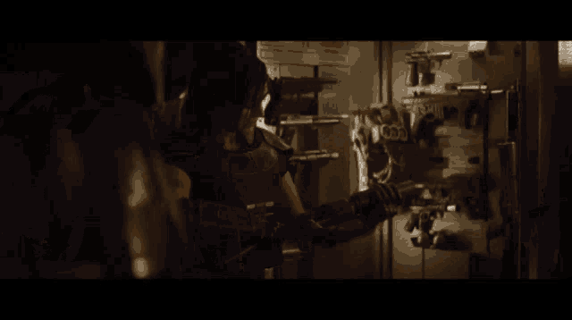a man holding a gun in a dark room with the number 666 on the wall