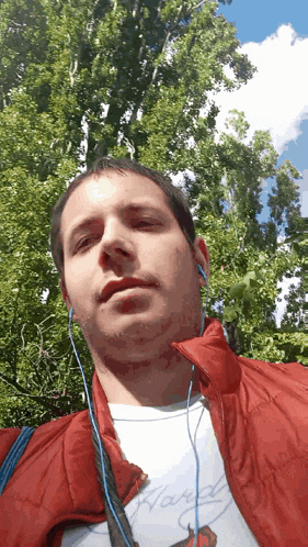 a man wearing ear buds and a hardy shirt