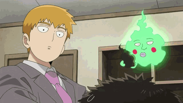 a man in a suit and tie stands next to a green monster