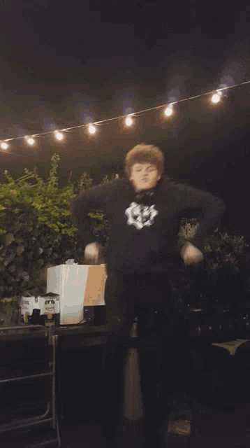 a man dancing in front of a grill that has a bottle of corona on it