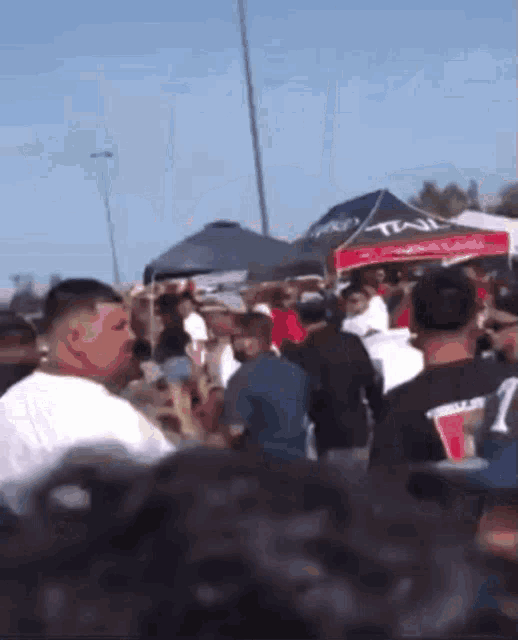 a crowd of people are gathered under a tent that says trail on it