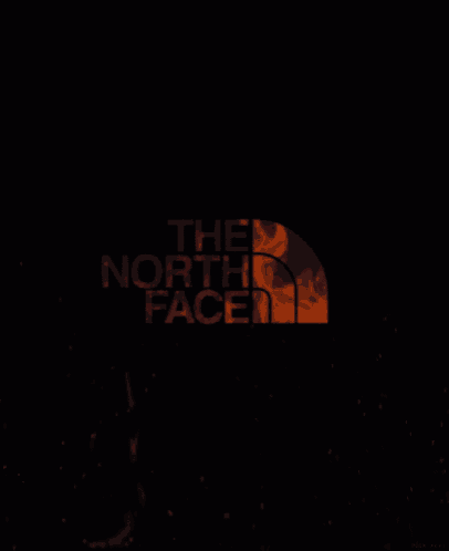 a logo for the north face with a picture of fire in the background