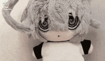 a stuffed animal that looks like a cat with a swirl in his eyes