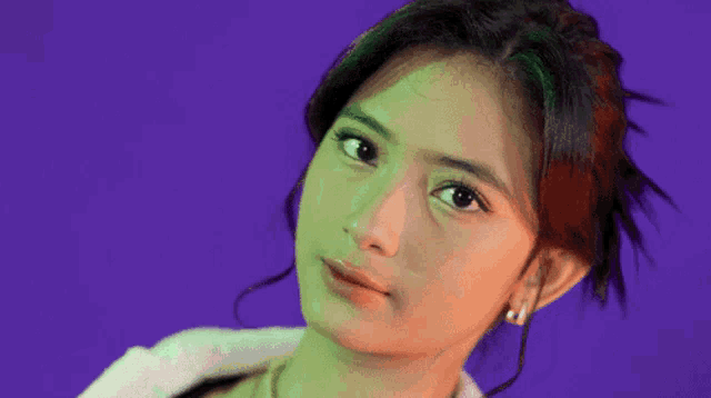 a close up of a woman 's face on a purple background