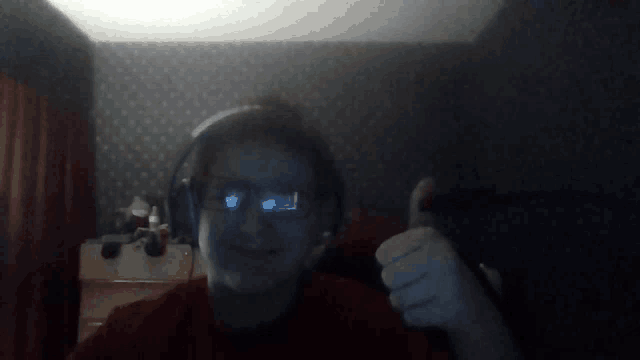 a man wearing headphones giving a thumbs up