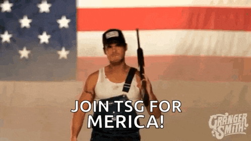 a man in overalls is holding a gun in front of an american flag .
