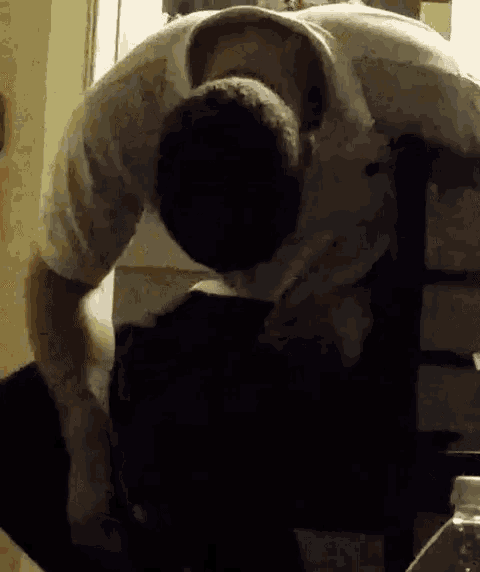 a man is sitting on a chair with his head down and looking down .