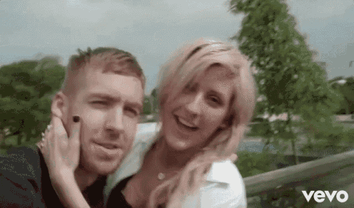 a man and a woman are posing for a picture with the word vevo on the bottom