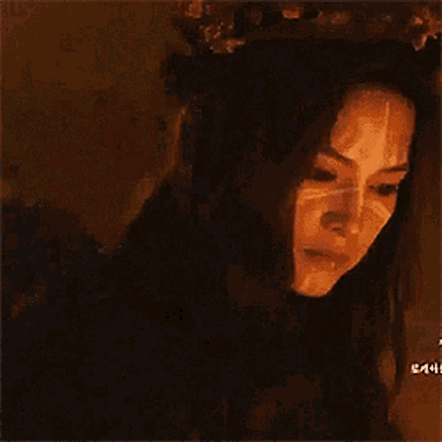 a woman with a crown on her head and face paint on her face .