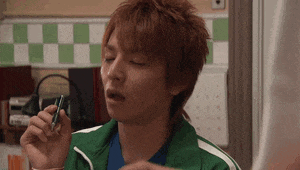 a man wearing a green jacket is holding a pen in his hand .